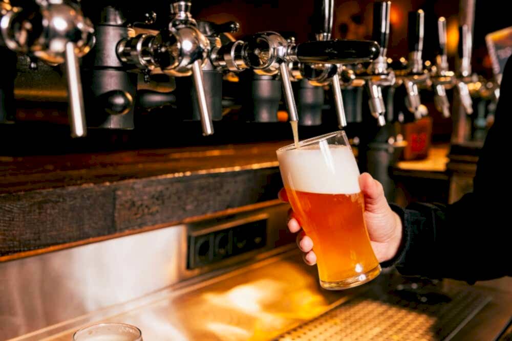 Someone pouring beer at one of the best Mid-Coast Maine breweries.